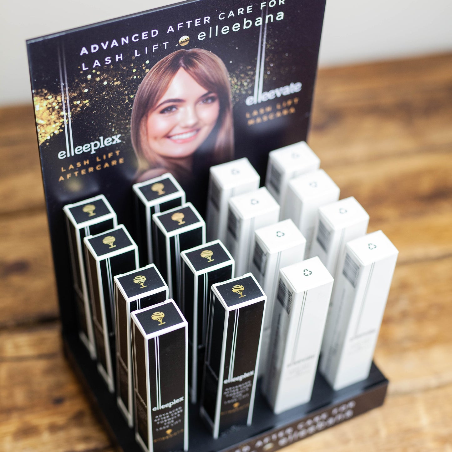 Sleek black countertop retail display stand holding Elleevate Lash Lift Mascaras and Elleeplex Aftercare Treatments for salon front-desk sales.