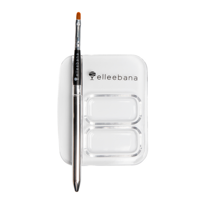 A sleek Elleebana application brush with its matching protective transformer casing, resting next to professional lash and brow tinting products on a clean salon surface.
