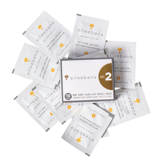 A pile of Elleebana Lash Lift individual sachets for Step 2 of the lash lift system, with each sachet labeled with the brand and product information.