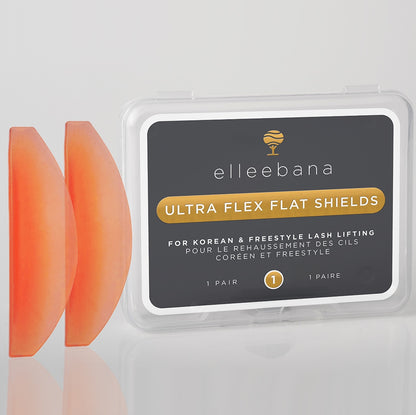 Pair of soft pastel-pink flexible silicone ultra-flat lash lift shields resting on a white studio backdrop.