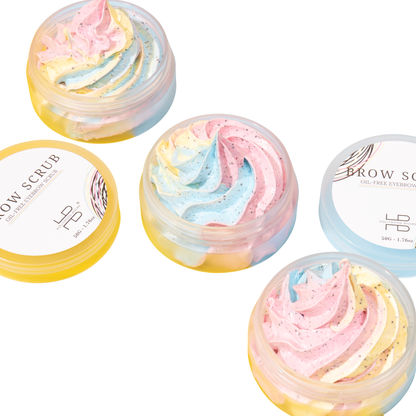 Container of Hollywood Brows oil-free powder-based brow scrub surrounded by fine ground apricot kernel exfoliants on a clean surface.