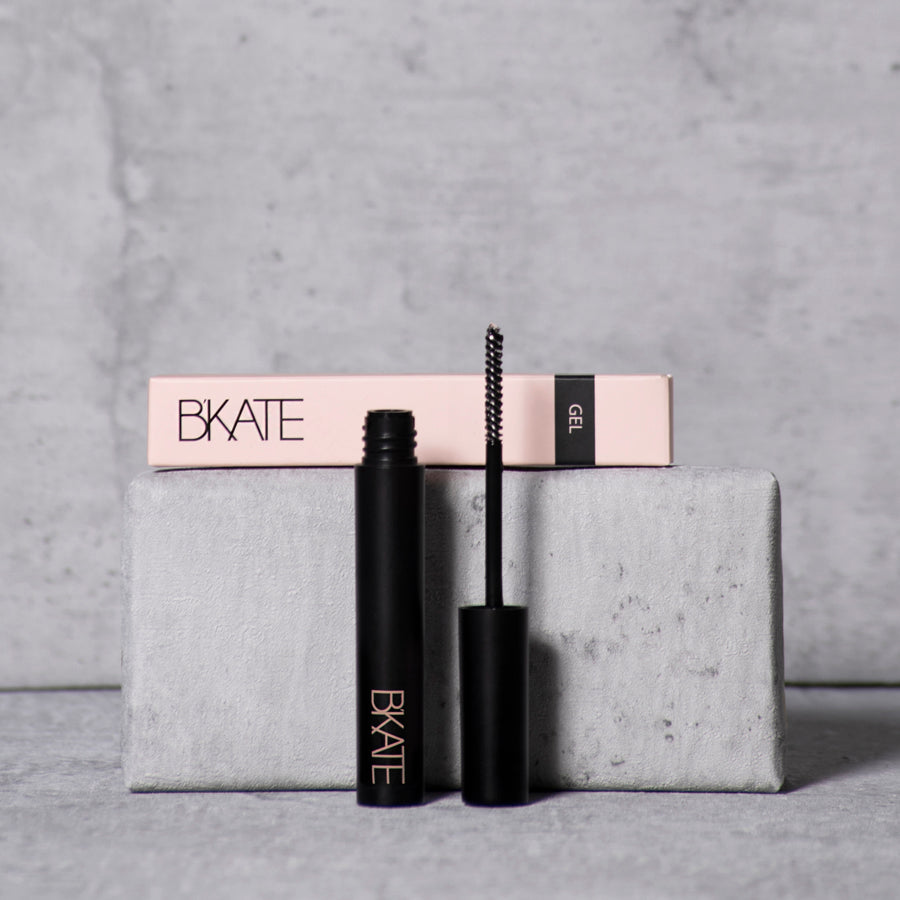 B'KATE brow gel tube next to its packaging box, featuring a fine spoolie brush designed to groom and set eyebrow hairs with a vitamin B5-enriched clear formula.