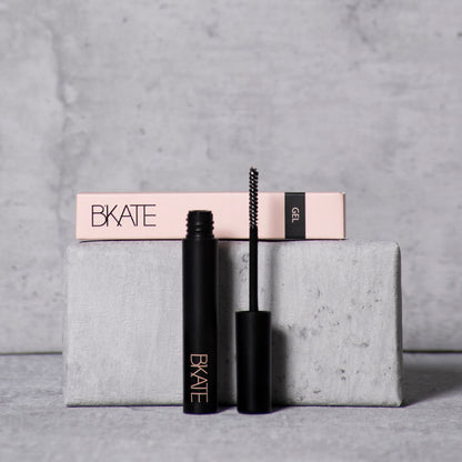 B'KATE brow gel tube next to its packaging box, featuring a fine spoolie brush designed to groom and set eyebrow hairs with a vitamin B5-enriched clear formula.