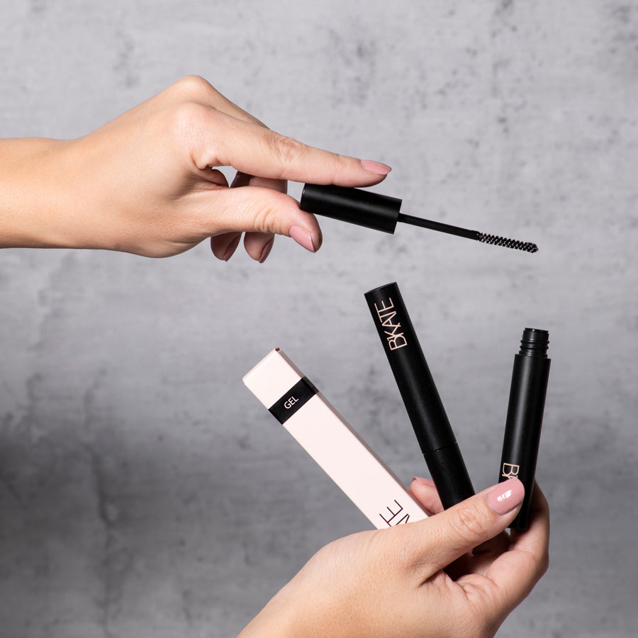  B'KATE brow gel tube next to its packaging box, featuring a fine spoolie brush designed to groom and set eyebrow hairs with a vitamin B5-enriched clear formula.