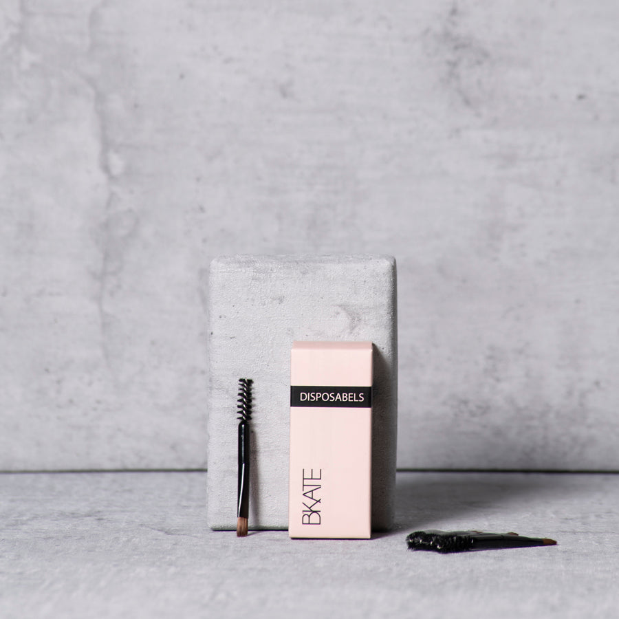 A set of 10 double-ended mini eyebrow brushes featuring an angled precision brush on one end and a spoolie on the other, designed for travel and quick on-the-go touch-ups.a