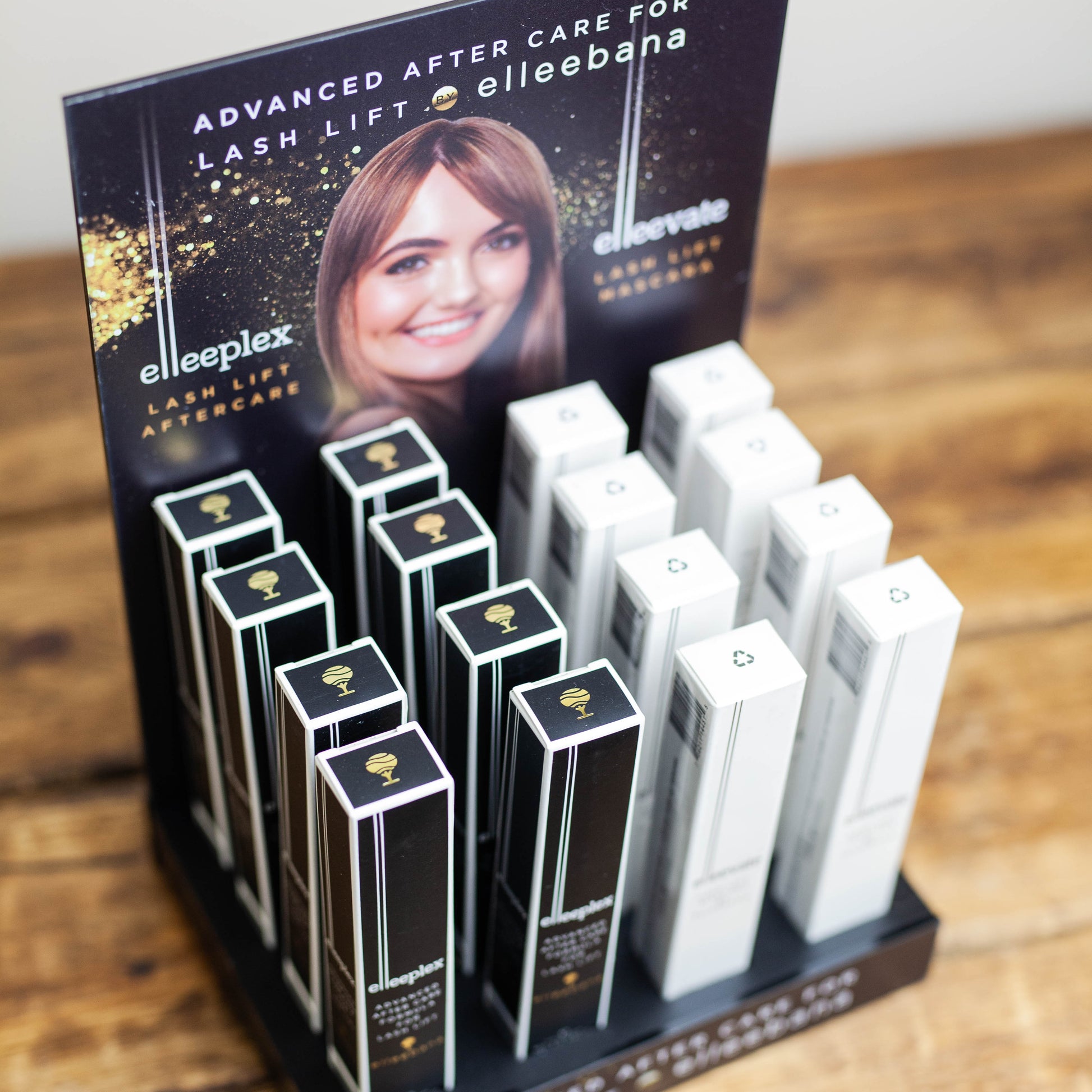Sleek black countertop retail display stand holding Elleevate Lash Lift Mascaras and Elleeplex Aftercare Treatments for salon front-desk sales.