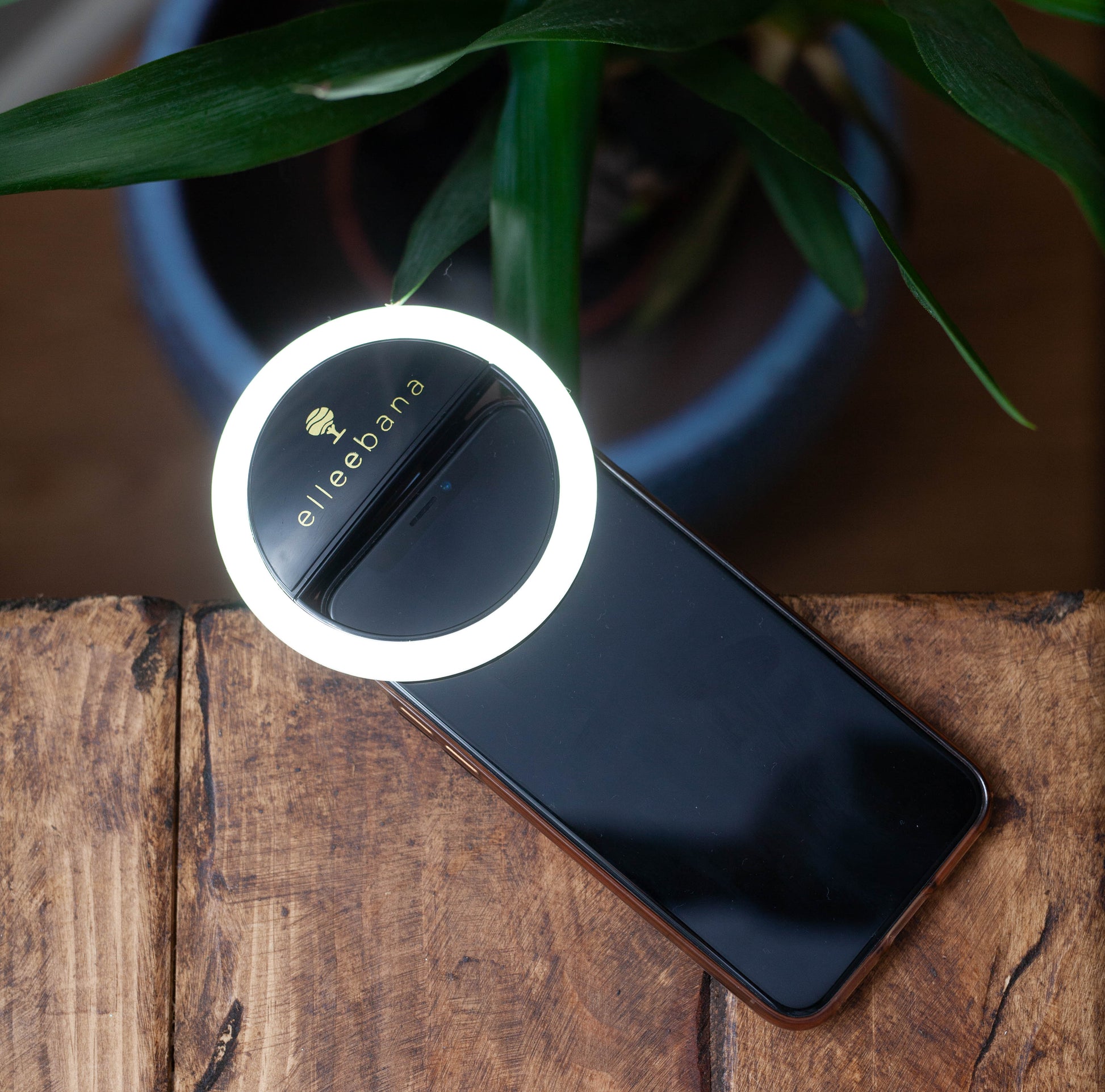Sleek black clip-on ring light designed for smartphones to illuminate close-up beauty photography, featuring adjustable brightness levels for clear before-and-after eyebrow and lash results.