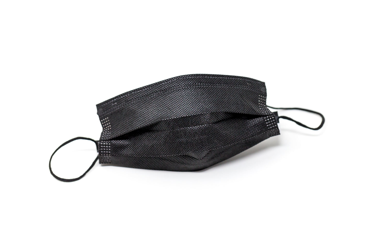 Medical-grade 3-ply blue disposable face mask in individual sterile plastic wrapping being pulled from a box, featuring soft earloops and fluid-resistant layers.