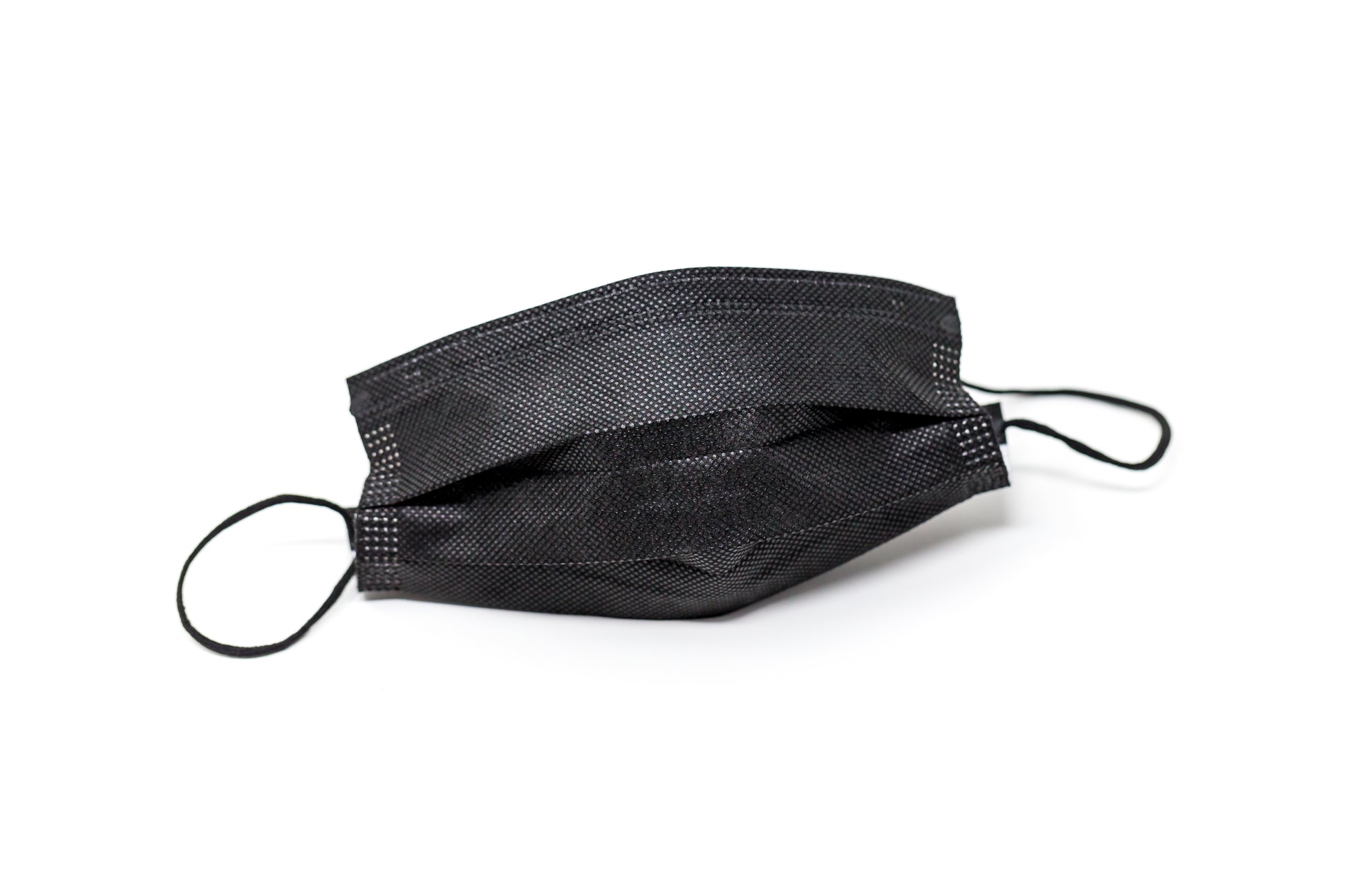 Medical-grade 3-ply blue disposable face mask in individual sterile plastic wrapping being pulled from a box, featuring soft earloops and fluid-resistant layers.