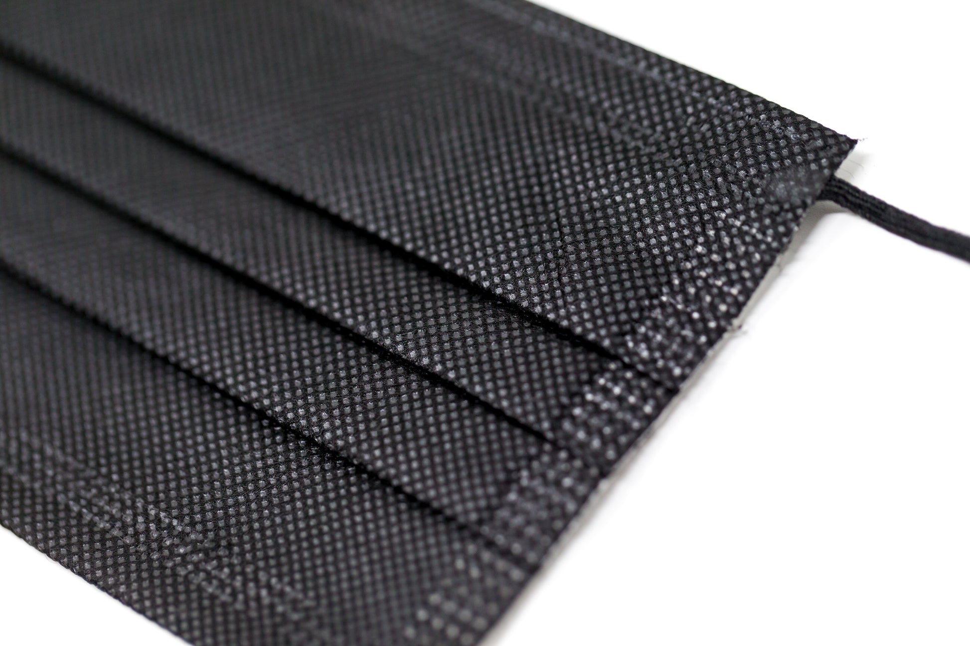 Medical-grade 3-ply blue disposable face mask in individual sterile plastic wrapping being pulled from a box, featuring soft earloops and fluid-resistant layers.