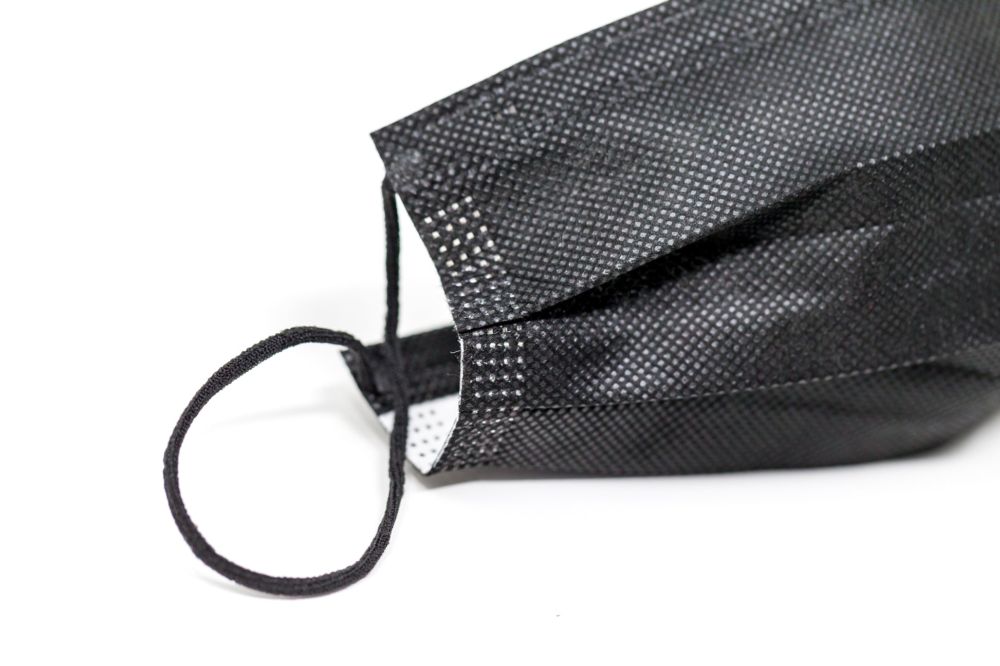 Medical-grade 3-ply blue disposable face mask in individual sterile plastic wrapping being pulled from a box, featuring soft earloops and fluid-resistant layers.